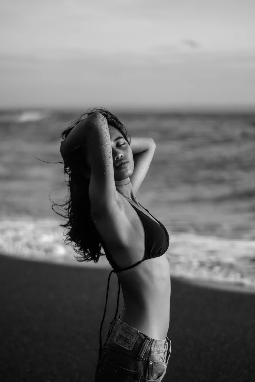 a girl in a bikini standing on the beach