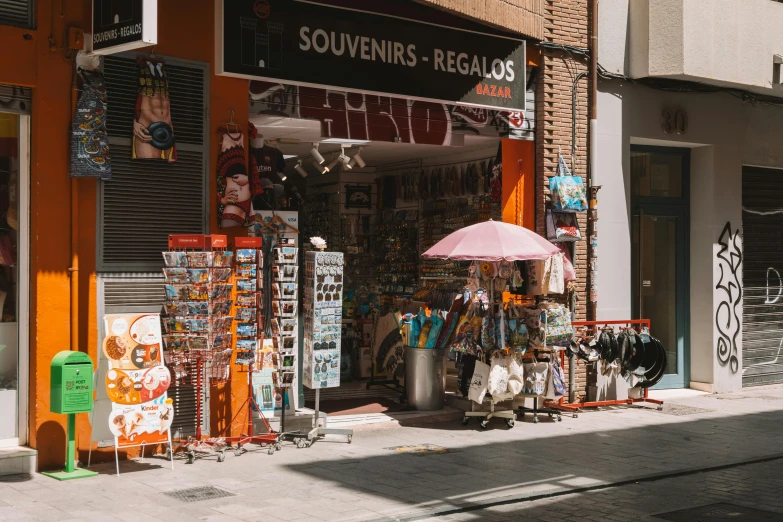 a street corner with a storefront, sign, and umbrella