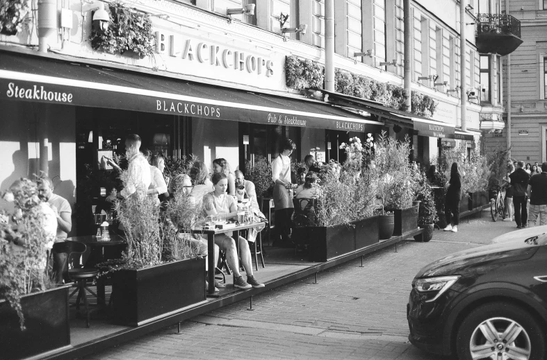 the people are outside of the black and white store