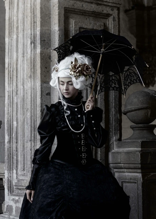 a lady with an elaborate black outfit and white hair