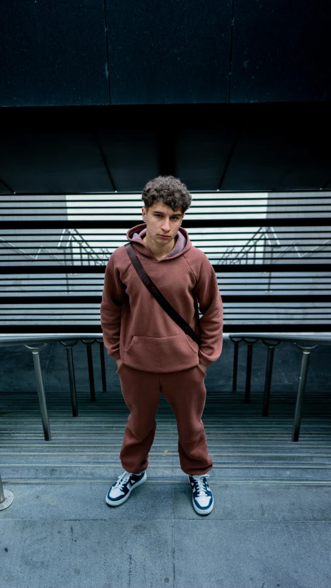 a young man wearing a hoodie and sweatpants