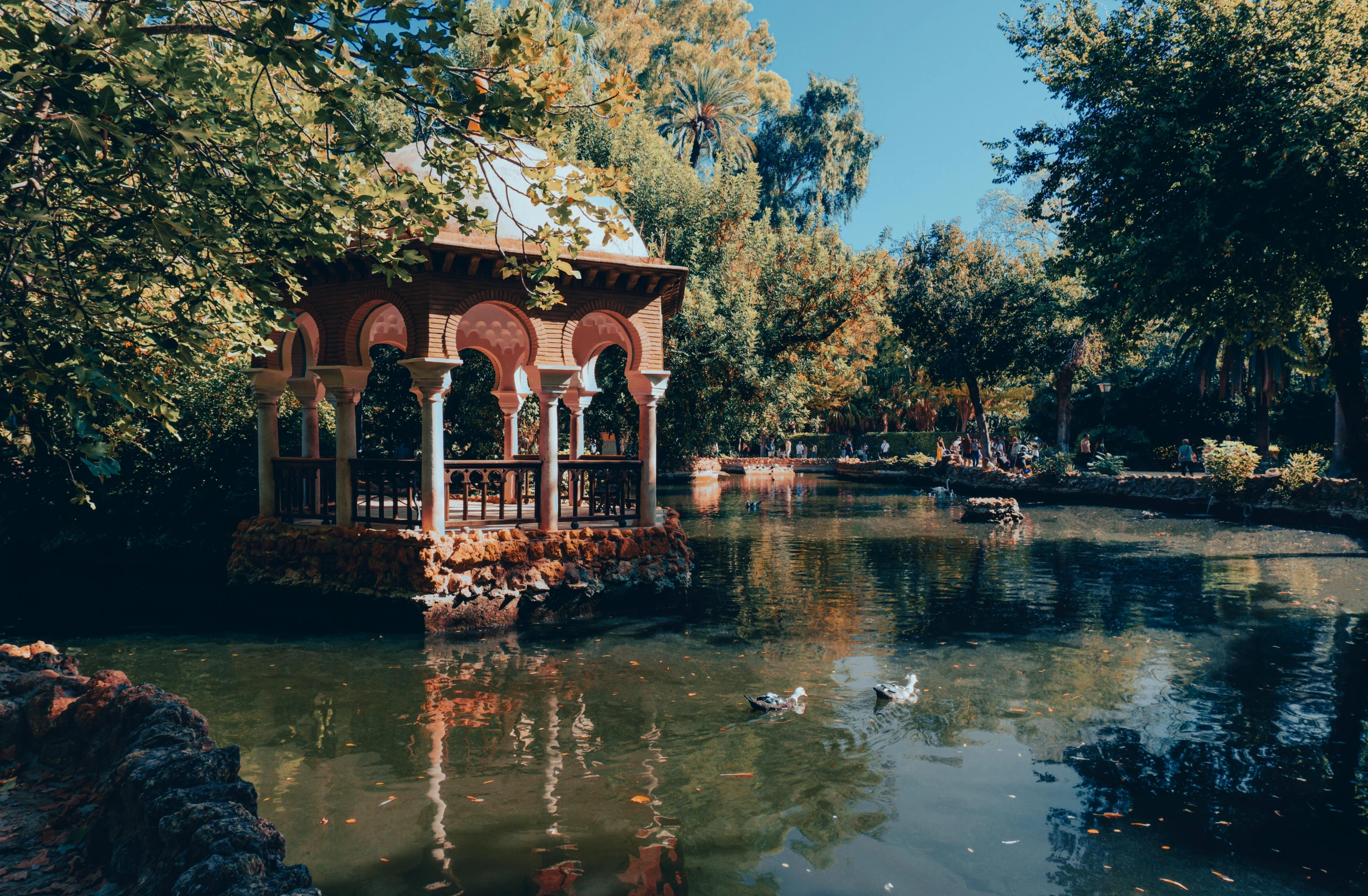 a gazebo in a park pond surrounded by trees