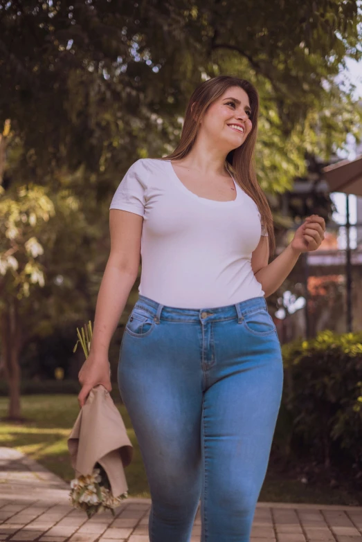 a beautiful young lady in tight jeans carrying flowers