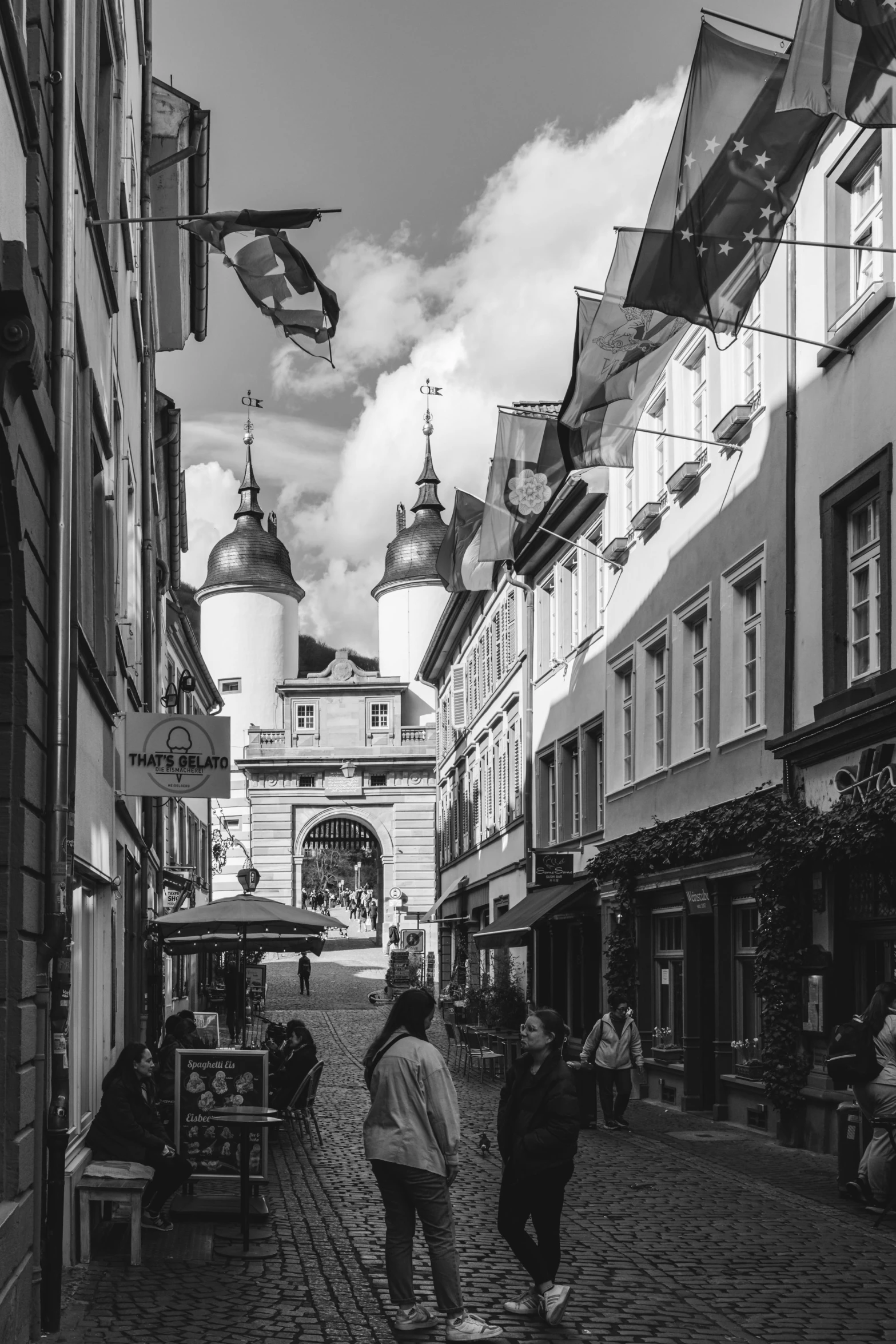 people walk down the street in black and white