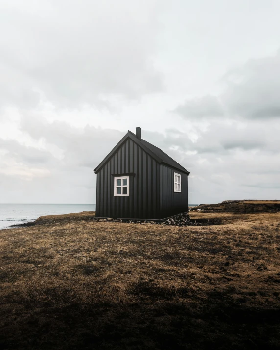 a little house sitting on top of a sandy beach