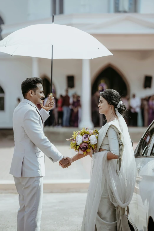 a bride and groom under an umbrella getting ready to ride