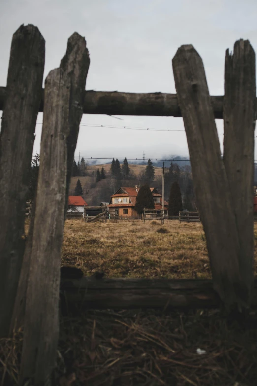 an old wooden fence with a house in the background