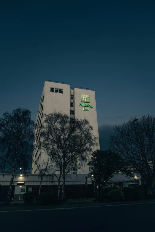 the tall building with trees beside it has a large sign