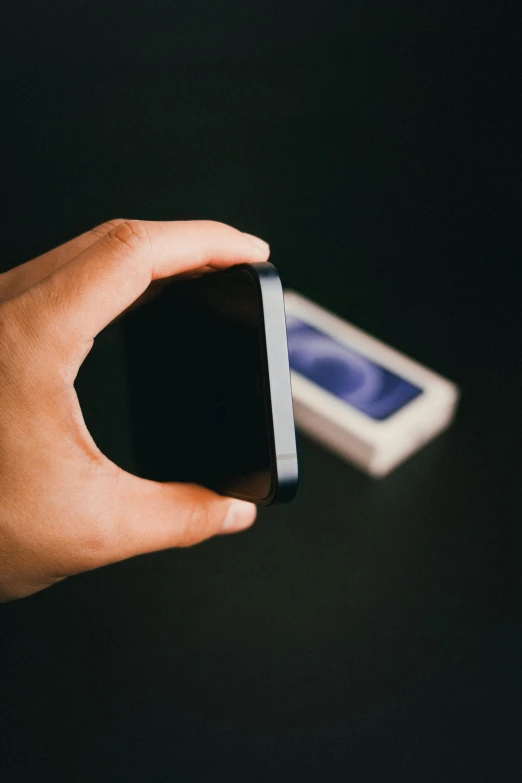 someone holding a cell phone in their hand with the screen down