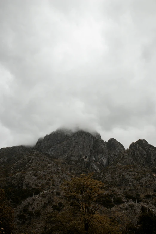 clouds rolling in and over the tops of mountains