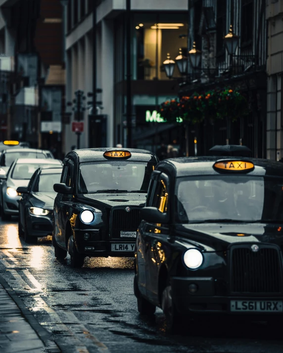 the taxi cabs are lined up in traffic on a rainy day