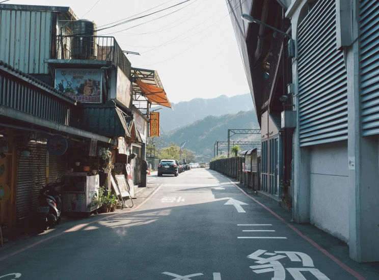 a street with a very small building on one side and no cars on the other