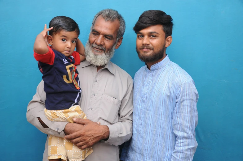 two men are holding a child and they look very happy