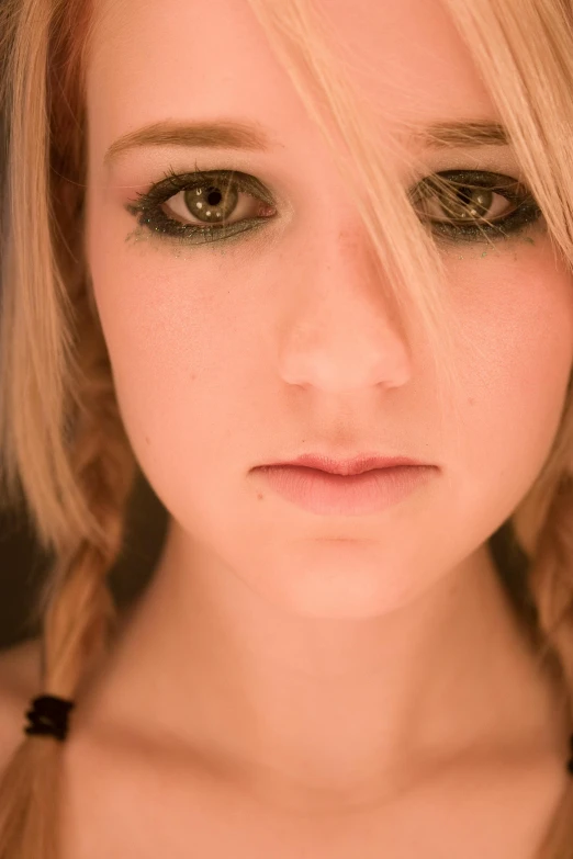 a girl wearing an updo and makeup, with dark green eyes