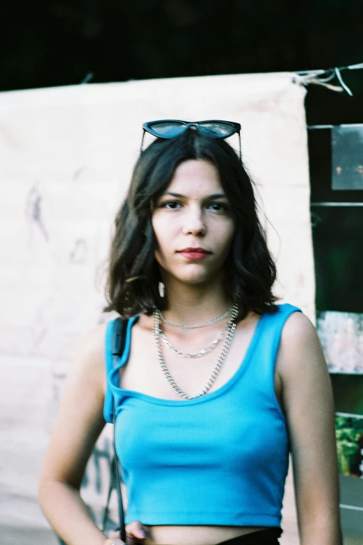 a woman wearing a crop top standing in front of a wall