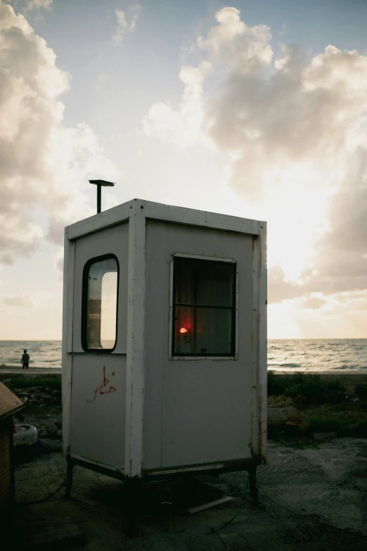 the small white building is set up next to the ocean