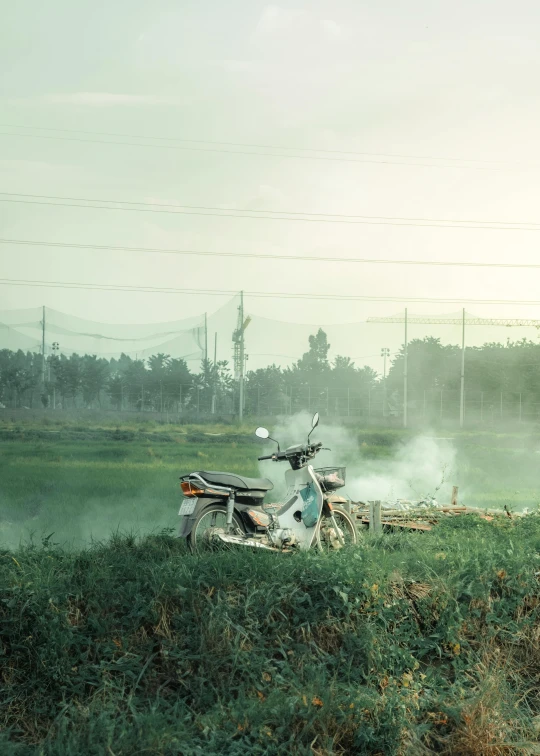 the motorbike is parked on the edge of the river bank