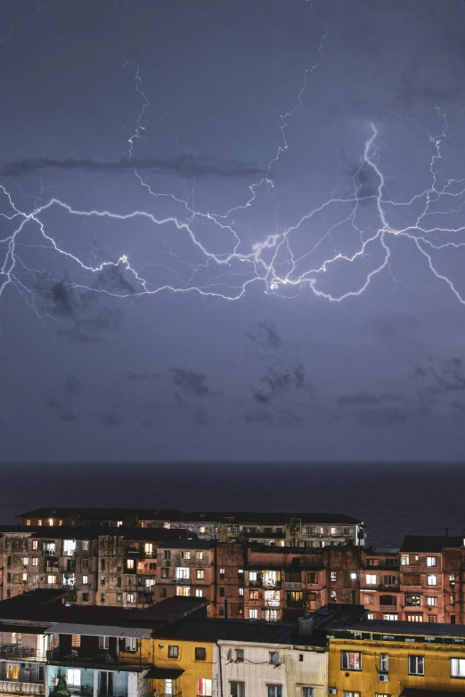 some big buildings and some big lightning on a cloudy day