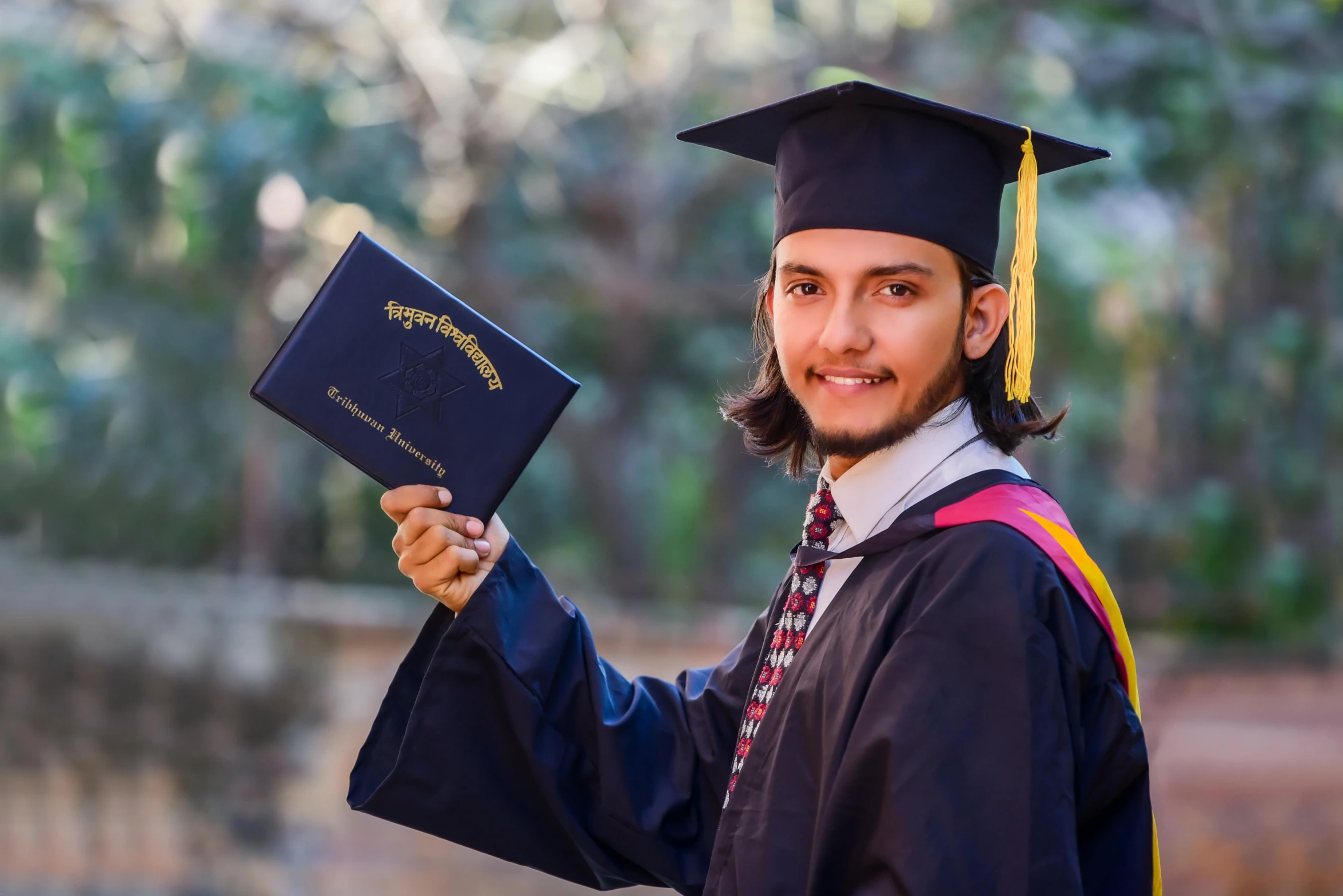 a man is posing for a picture with his graduation diploma