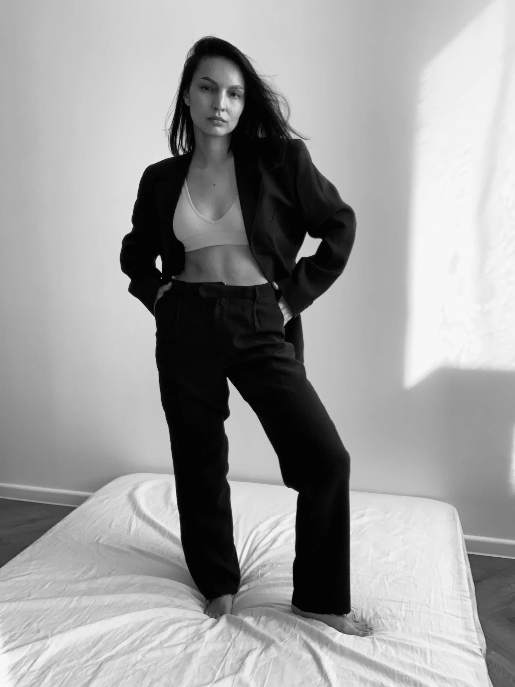 a young woman poses in her underwear on top of a bed