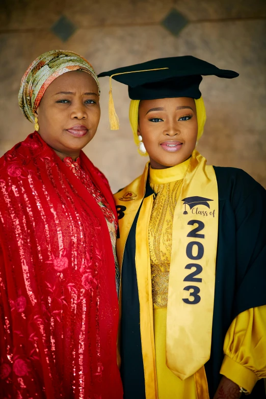 two girls in graduation gowns pose for a picture