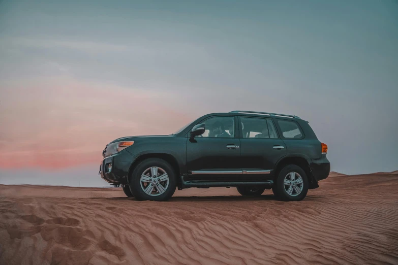 the large suv is parked in the desert