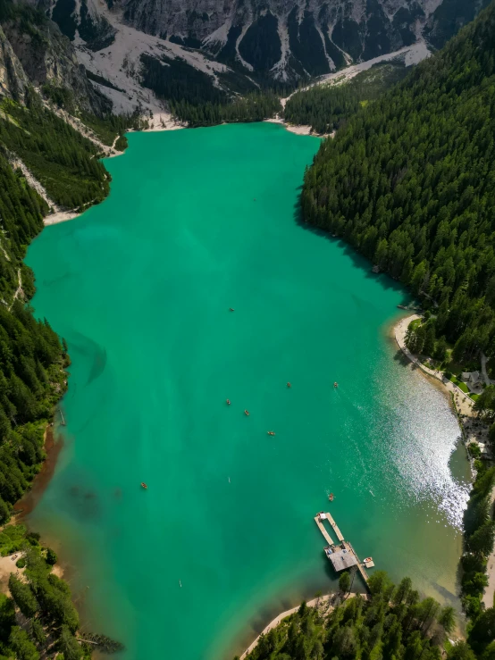 an aerial view of the green lake and the surrounding mountains