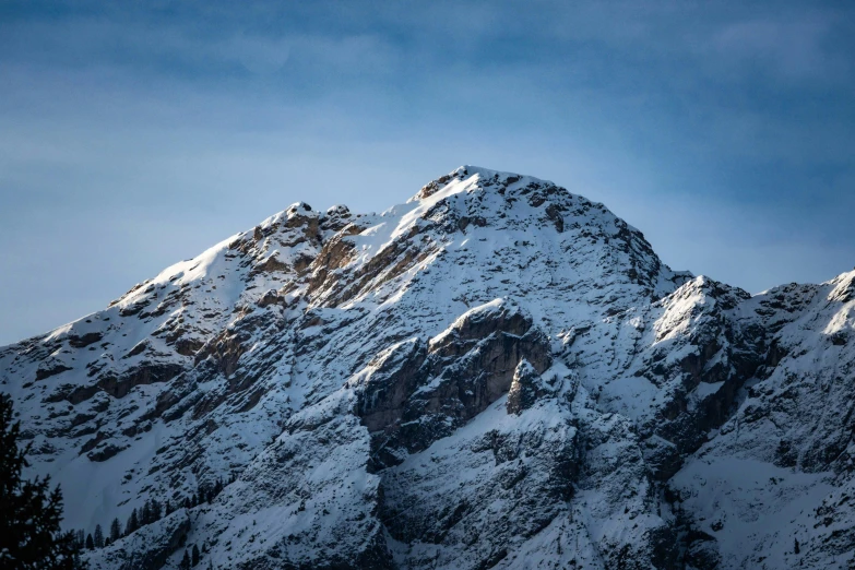 a mountain is covered in snow against a blue sky