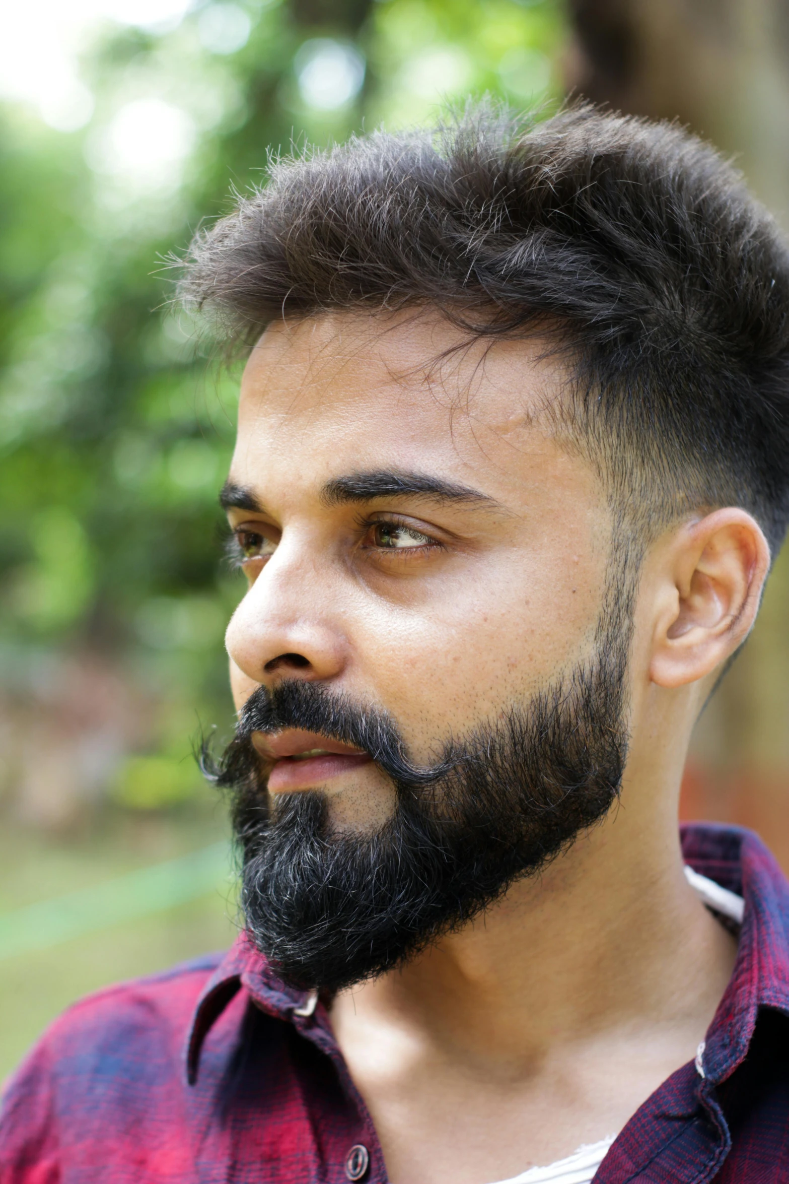 a close - up image of a man with a beard and plaid shirt