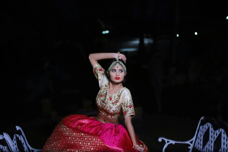 a woman in red and gold clothing standing on stage