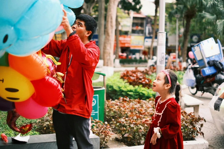 two people that are holding up some balloons