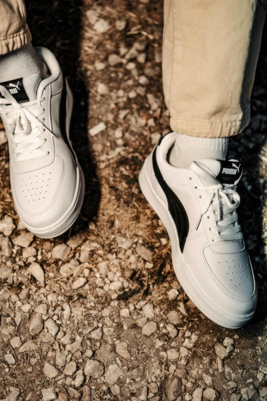 a pair of white sneakers sit on a stone surface