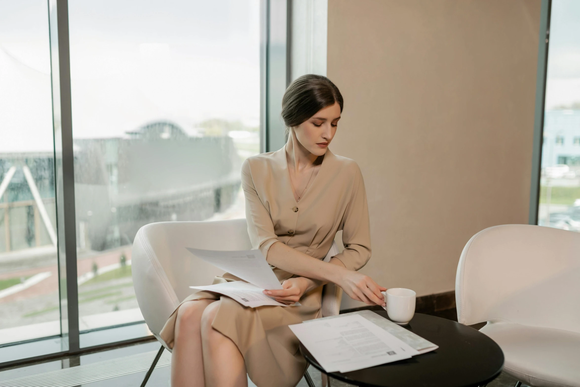 a woman sitting on top of a chair holding papers