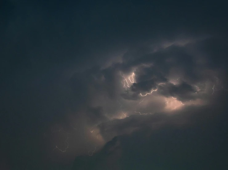 a very dark storm with some lightning on the sky