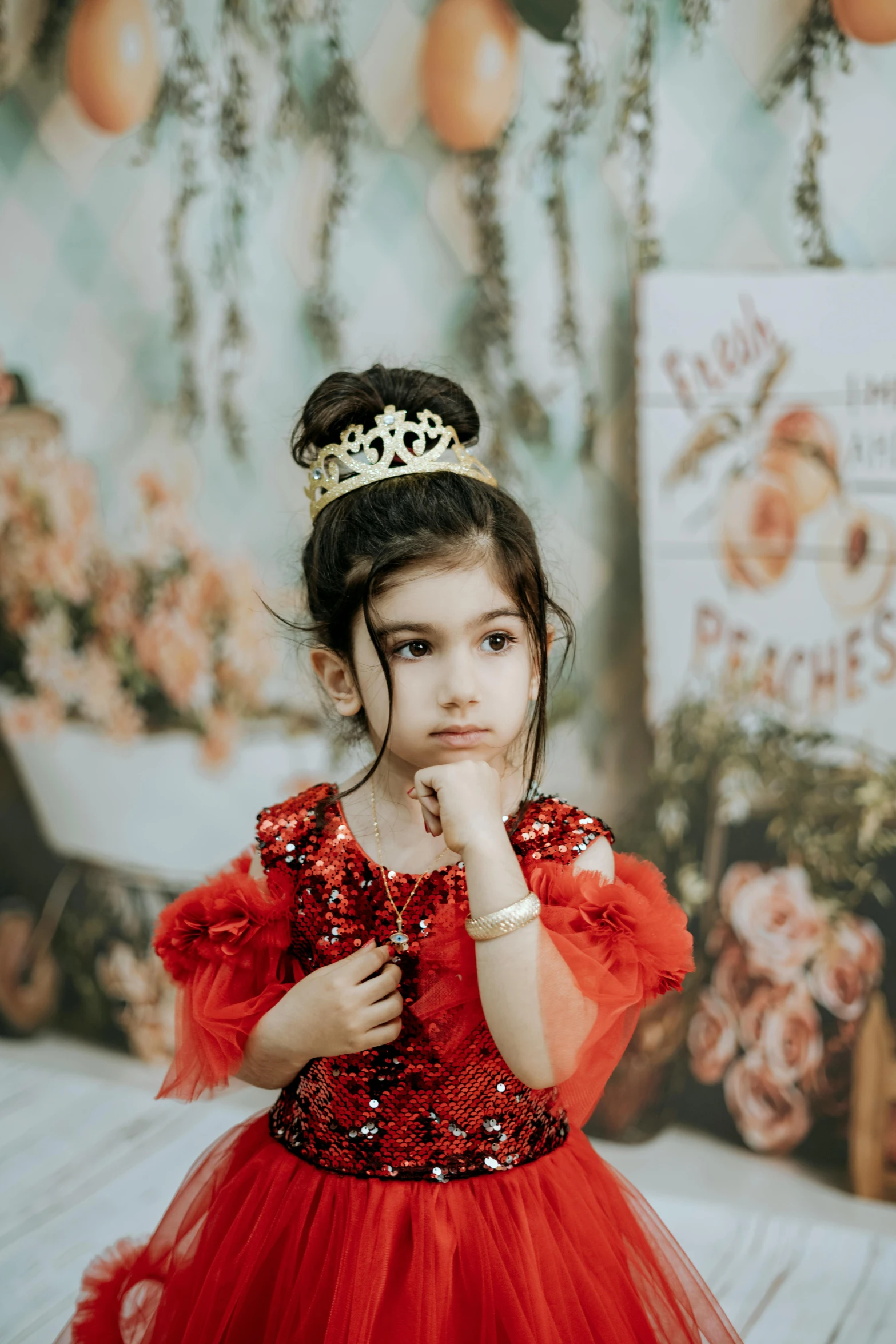 a little girl with a tiara on and red dress