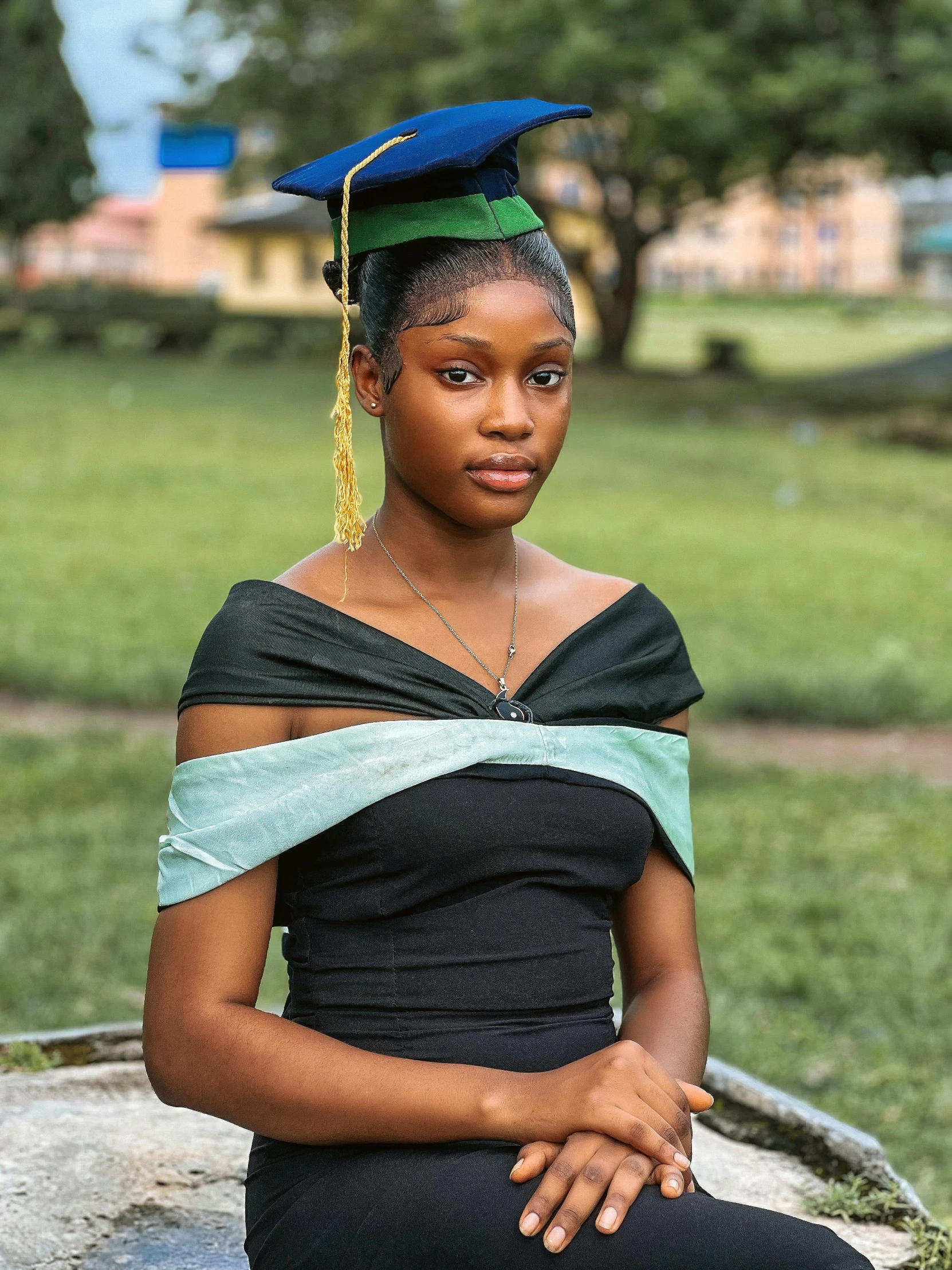 a woman wearing an graduation cap sitting in a field