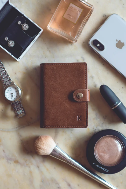 the contents of an iphone and cosmetics are displayed on a table