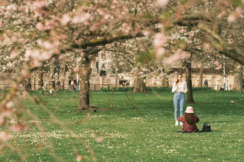 two women in a park in front of trees