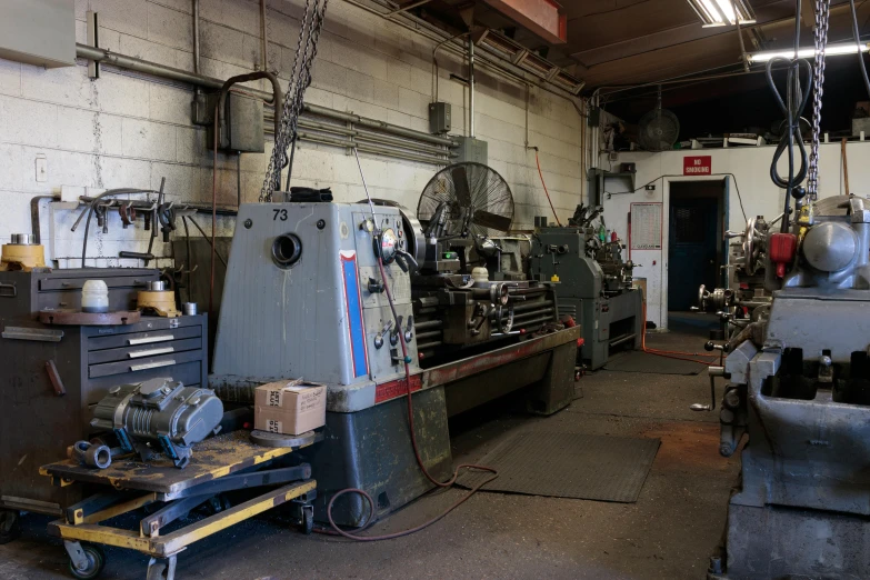 a factory room with machinery, shelves and tables