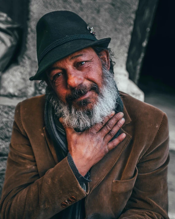 a man with a hat and beard looks into the camera