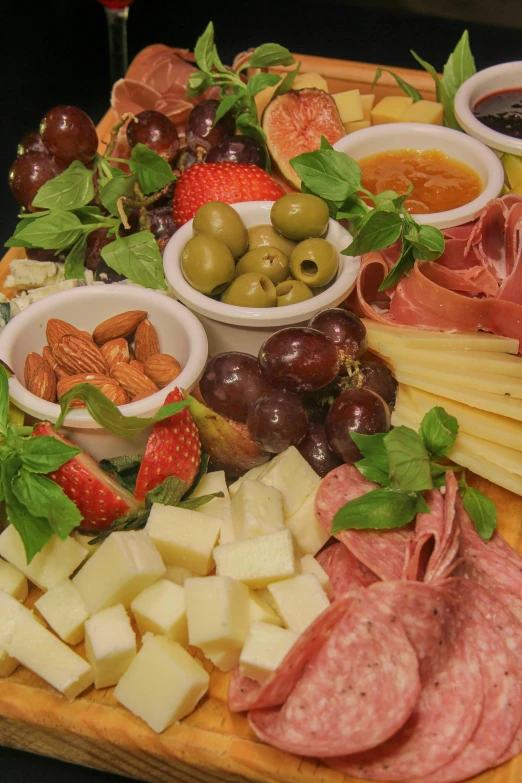 an assortment of meats and cheeses on a board