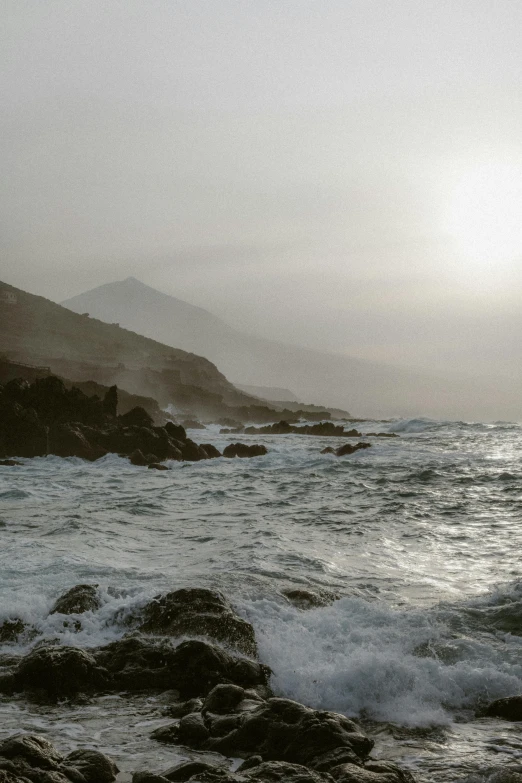 some people surfing on the waves near a rocky shoreline