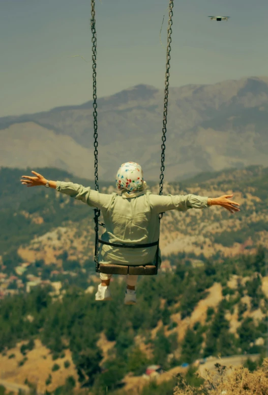 man in jacket hanging from chair with arms outstretched