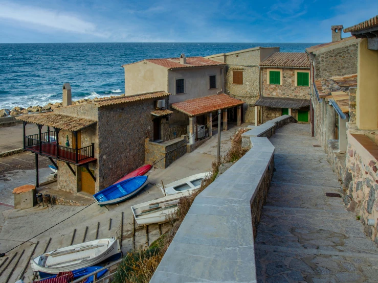 boats are parked along the beach as buildings overlook the water