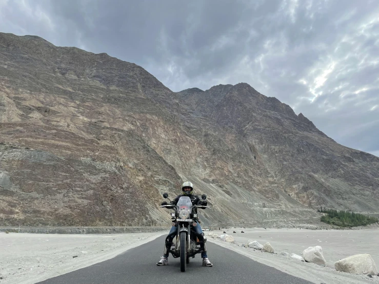 two motorcycles are parked on a small road