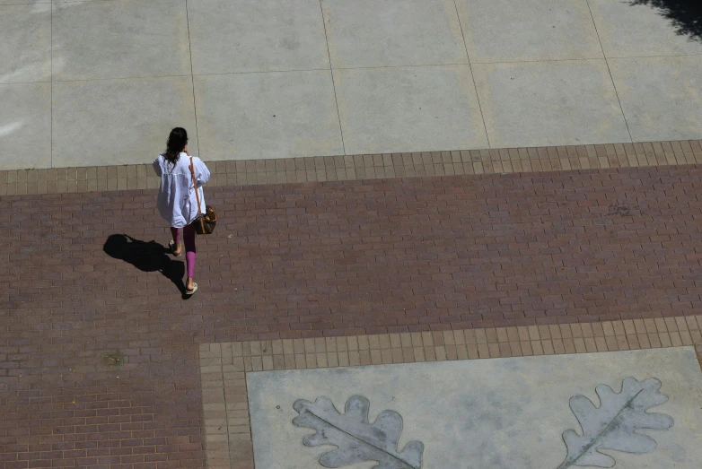 the woman walks by her artwork on the sidewalk