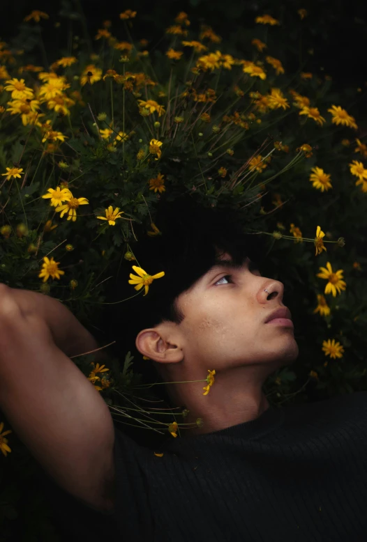 a man laying in a field of flowers