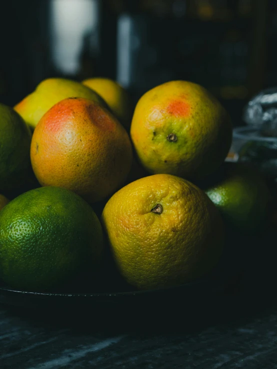 there are lemons and limes sitting in the bowl on the table