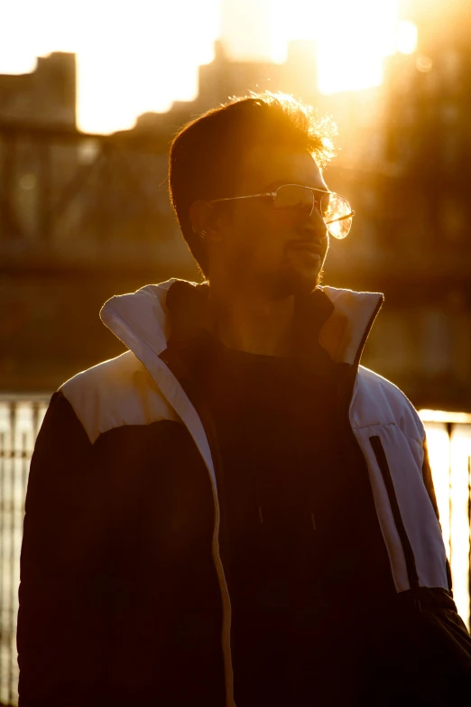 a person standing near some buildings at sunset