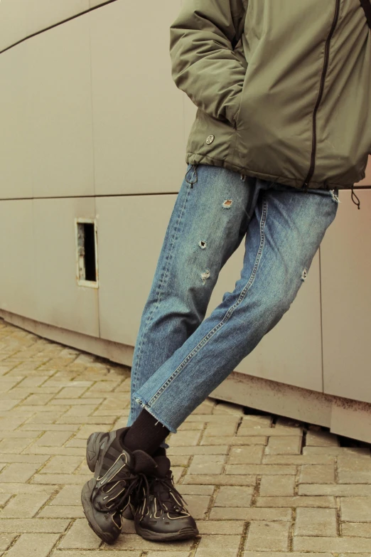 a person is wearing a pair of ripped jeans and high - top sneakers